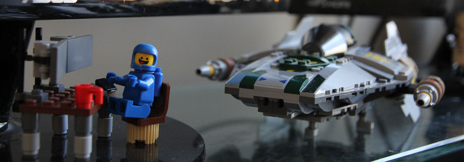 Lego Benny Sitting at Desk in front of A-Wing